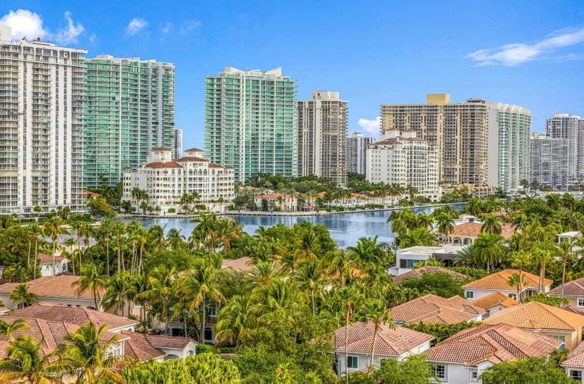 Palm trees, tile roofs and high-rise towers around the water in South Florida